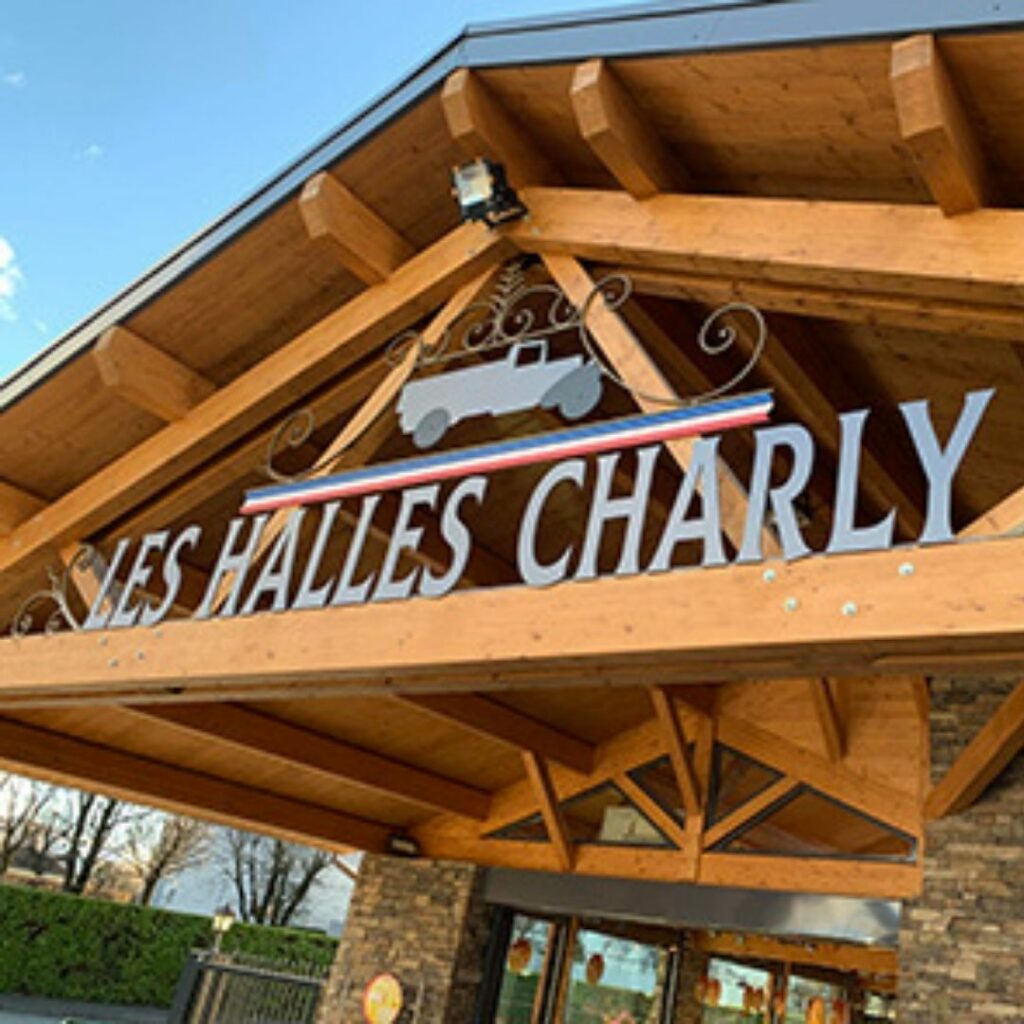 La façade en bois des Halles Charly, avec son enseigne au camion